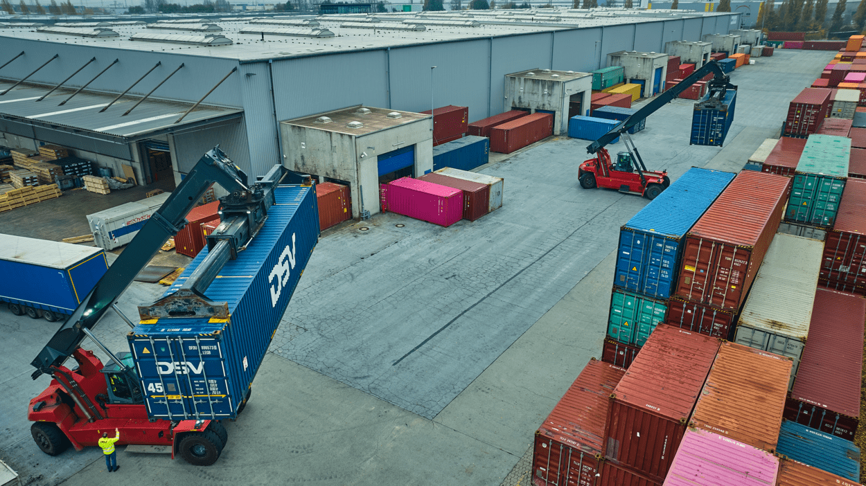 Trucks bærer og distribuerer DSV-containere utenfor terminal, som blir plassert oppå hverandre